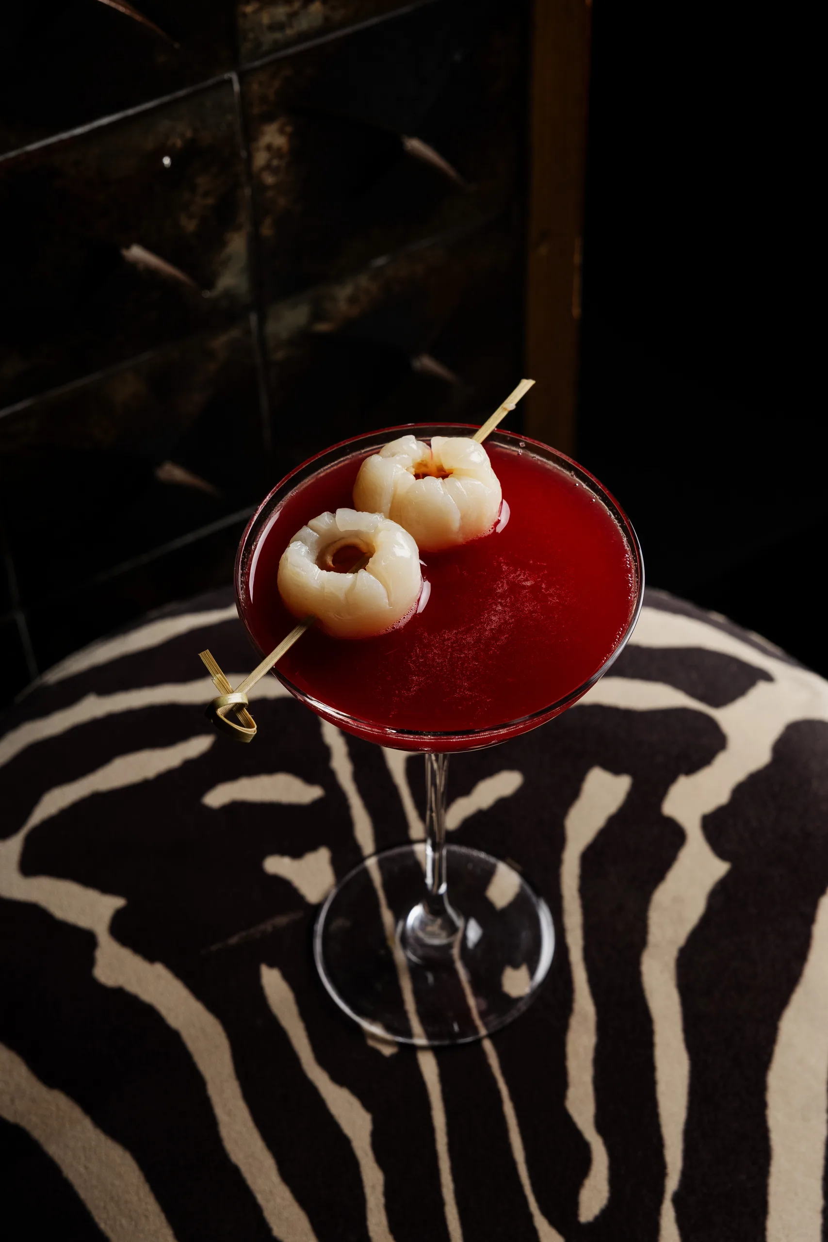 Red cocktail with lychees on zebra print