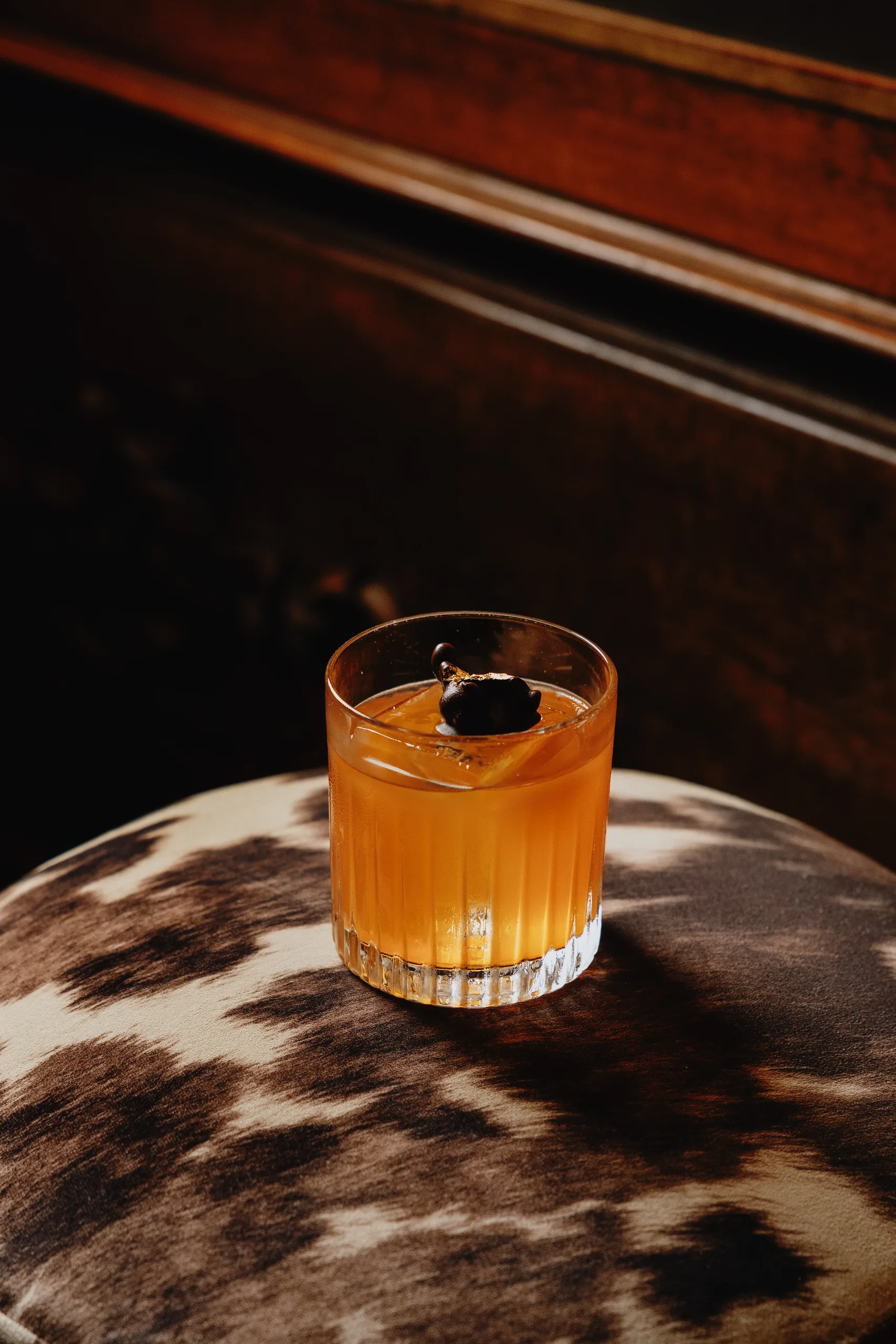 Amber cocktail on a cowhide stool