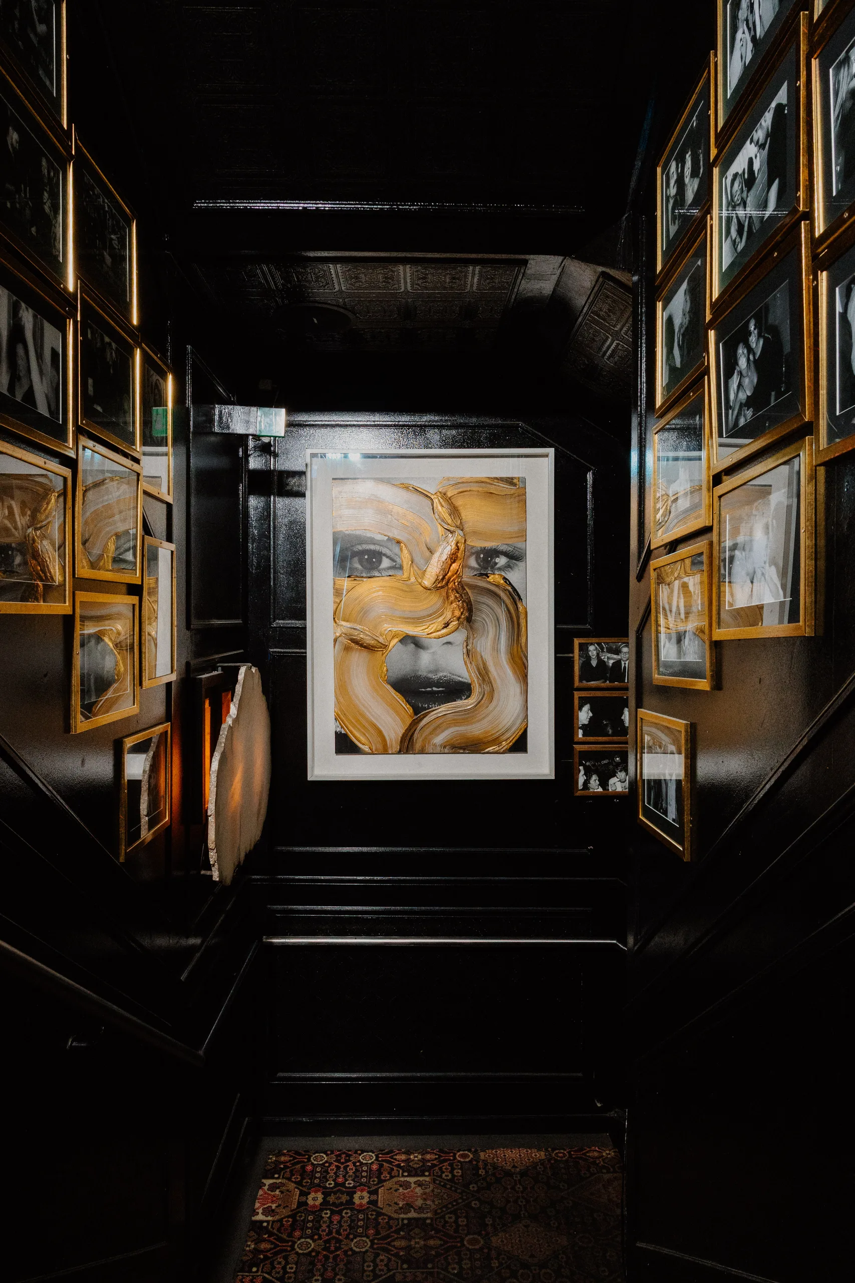 Gold-painted portrait at the end of the black gallery hallway