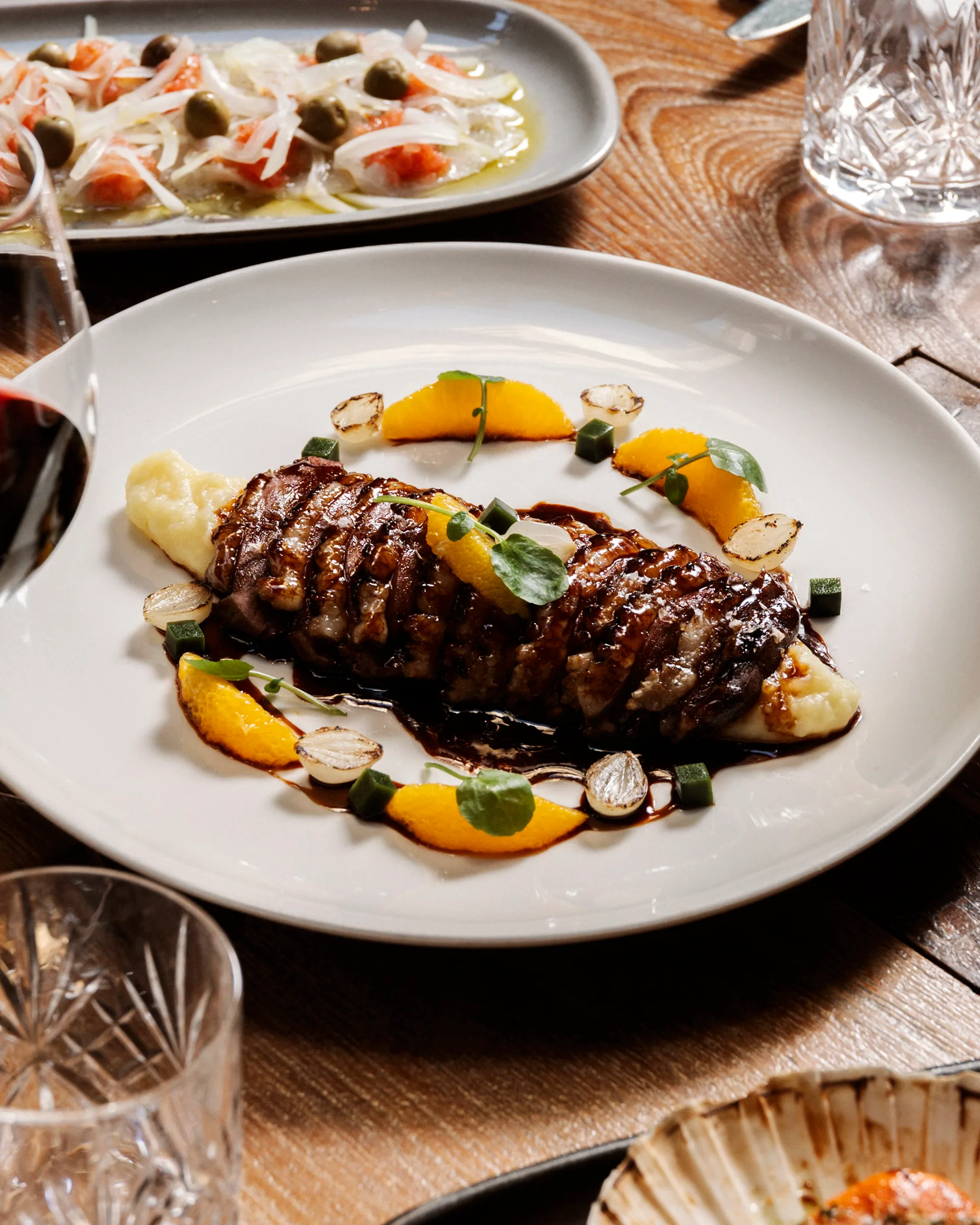 Plated duck with orange and pearl onions at Boca Grande